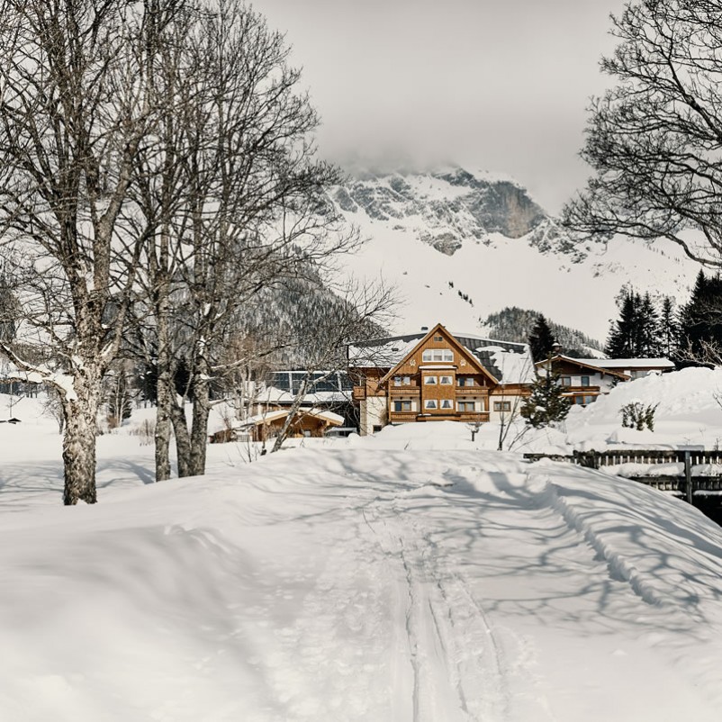 Blick zur Pension im Winter, Berge im Hintergrund