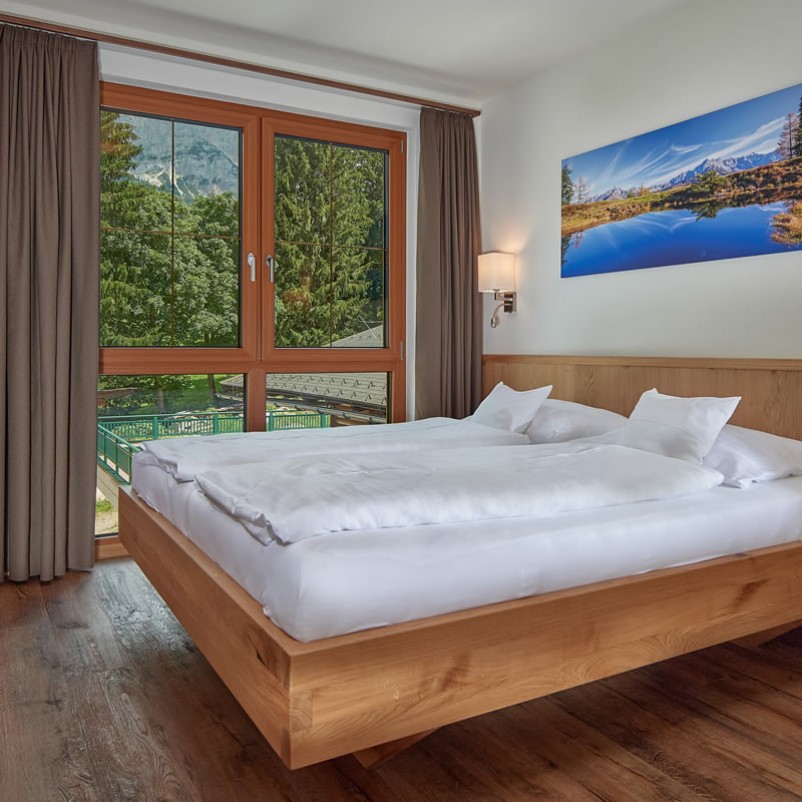 Doppelbett mit großem Fenster mit Blick in die Natur